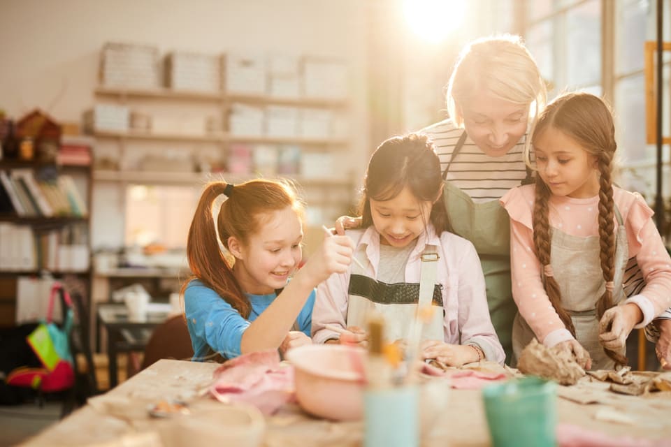 Senior woman doing crafts with children