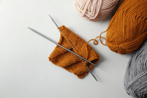 Image of silver knitting needles attached to a partially knitted project